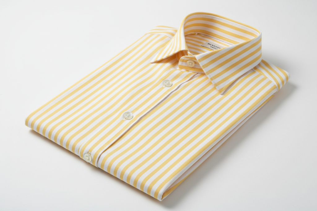 2 – Yellow & White Vertical Stripe Oxford (Resort Luxe
Comfort)
• Category: Smart Casual / Resort Premium
• Fabric: 97% Long-Staple Cotton + 3% Lycra Oxford
• Yarn Count: 80/2 × 40/2
• Weight: 145–150 g/m²
• Weave: Oxford 2×2 Basket
• Finish: Enzyme Washed, Liquid Ammonia, Nano Wrinkle-
Resistant, Pre-Shrunk
• Pantone: 13-0850 “Primrose Yellow” × 11-0601 “White” FOLDED PREMIUM 